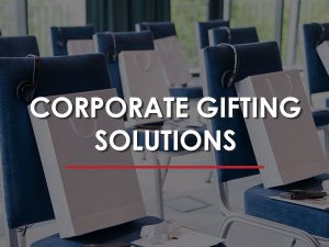 A row of chairs with bags on the back of them, set in a corporate space.