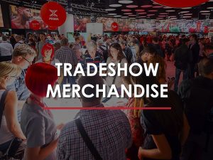 A large group of people attending a trade show in an auditorium.